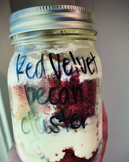 A Red Velvet Pecan Cluster cake jar with the flavor written on the glass
